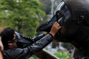 A group of environmentalists place gas masks on the faces of the sculptures of the artist Fernando Botero, protesting the high levels of air pollution in Medellin