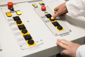 Hand pushing the button on the control panel
