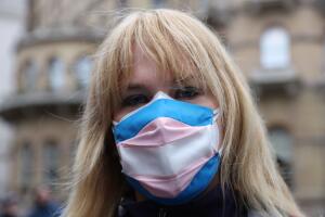 Mujer usando cubrebocas con el estampado de la bandera trans