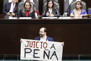 El legislador Emilio Álvarez Icaza levanta un cartel que dice "Juicio a Peña" en referencia al expresidente mexicano Enrique Peña Nieto.