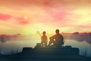 Father with son in the morning fishing from a wooden pier