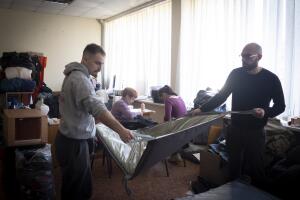Kostya Andreev muestra, junto a otro voluntario, una de las colchonetas que cosen en el centro de voluntarios de Zaporiyia para los soldados.