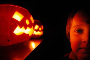 Un niño disfruta de las tradicionales calabazas de Halloween a la luz de las velas. 