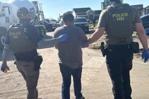 Agentes estatales arrestan a un trabajador en un área de trabajos de contrucción.