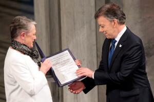 Nobel Peace Prize laureate Colombian President Juan Manuel Santos receives the medal and diploma from the Norwegian Nobel Committee member Berit Reiss-Andersen during the Peace Prize awarding ceremony at the City Hall in Oslo