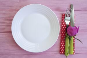 plate of fork knife flower peony on pink wooden background