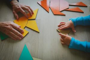 teacher and child playing with geometric shapes