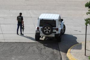A cartel gunmen wearing a flack jacket stands next to his vehicle during clashes with federal forces following the detention of Ovidio Guzman, son of drug kingpin Joaquin "El Chapo" Guzman, in Culiacan