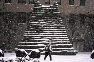 Una persona pasa junto a unas escaleras nevadas en el centro de Pittsburgh.