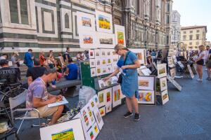Artists paint and sell their paintings by the wall Cathedral in Florence, Tuscany, Italy