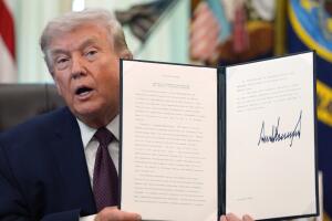 Donald Trump sostiene una orden ejecutiva firmada