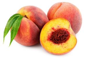 Peach with half and leaf isolated on white