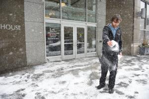 Un empleado vierte sal en la entrada de un edificio de oficinas en Detroit