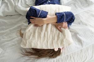 Mujer durmiendo abrazada a su almohada