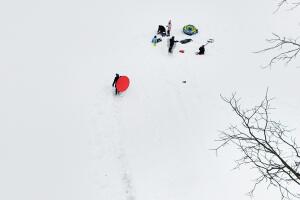 Niños se reúnen mientras se deslizan en trineo, el lunes 23 de febrero de 2026, en Kings Park, Nueva York. 