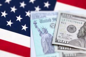 United States IRS Check, Envelope and Money Resting on American Flag