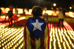 Una voluntaria lleva la bandera independentista catalana en la espalda en un acto a favor de marcharse de España.