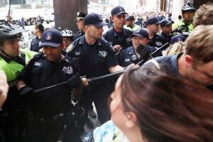 Anti-racism protesters react as police try to move them during protests in front of Trump Tower in New York City