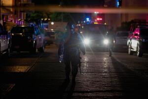 Police officers walk at a crime scene following a deadly attack at a bar by unknown assailants in Coatzacoalcos