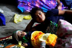 Migrantes hondureños que cruzaron la frontera con Guatemala duermen bajo una carpa.