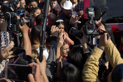 Rubi Ibarra arrives at the site of a Mass that is part of her down-home 15th birthday party, surrounded by a horde of journalists, in the village of La Joya, San Luis Potosi State, Mexico, Monday, Dec. 26, 2016. Millions of people responded to the invitation for Rubi's Dec. 26th coming of age party in rural northern Mexico, after her parent's video asking "everybody" to attend went viral. An estimated 300 were on hand for the Mass. (AP Photo/Enric Marti)