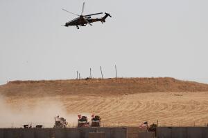 FILE PHOTO: A Turkish military helicopter flies over as Turkish and U.S. troops return from a joint U.S.-Turkey patrol in northern Syria, as it is pictured from near the Turkish town of Akcakale