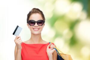 smiling woman with shopping bags and plastic card