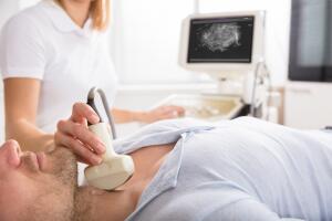 Male Patient Undergoing Ultrasound Of Thyroid