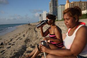 Según informó el Servicio Meteorológico Nacional (NWS), la ola de calor se insensitifcará, durante esta temporada, en los condados de Miami-Dade, Broward y Monroe. En la foto, Asha Shaw y su hija Amanda Shaw beben agua mientras se oculta el sol. 