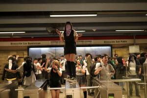 A demonstrator stands on the turnstiles of a subway station during a protest, in Santiago