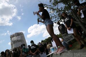 Manifestantes contra la brutalidad policial frente a estatua de Martin Luther King