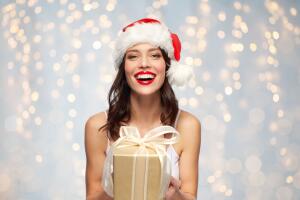 woman in santa hat with christmas gift