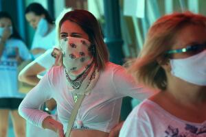 People wearing face masks wait to enter a Trader Joe's