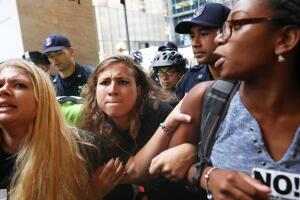 Anti-racism protesters react as police try to move them during protests in front of Trump Tower in New York City