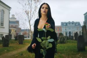 Morticia Addams frente a una tumbra Wednesday Merlina netflix.jpg