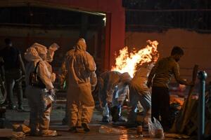 Parientes en traje protector observan la cremación de un ser querido fallecido por covid-19 en Nueva Delhi el 28 de abril del 2021.