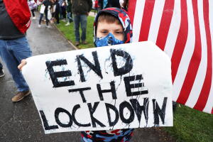 
Un niño sostiene un pancarta en una manifestantes para contra las medidas de quedarse en casa en Commack, Nueva York.