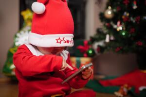 Happy santa baby girl play mobile phone