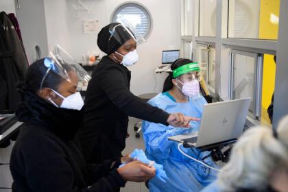 Lab staff wear personal protective equipment (PPE) while collecting tests from travelers in an on-site Covid-19 testing laboratory at Los Angeles International Airport (LAX) on December 31, 2020 in Los Angeles, California. - The rapid testing facility provides test results for travelers in about 3-5 hours. (Photo by Patrick T. Fallon / AFP) (Photo by PATRICK T. FALLON/AFP via Getty Images)