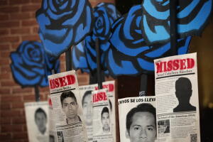 Activistas cuelgan carteles de los estudiantes de Ayotzinapa durante una marcha